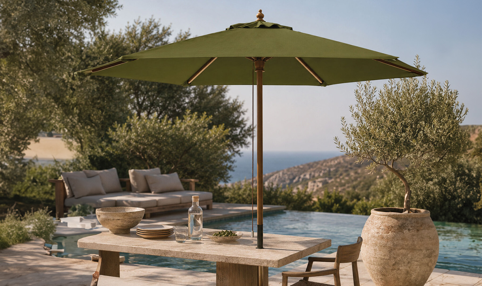Modern outdoor umbrella positioned beside a swimming pool overlooking a sunlit Mediterranean-style landscape